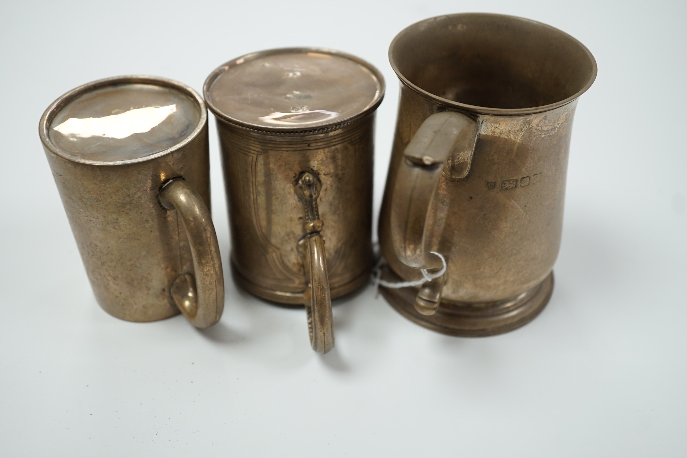 A Victorian engraved silver christening mug, The Barnards, London, 1871, 82mm and two later silver mugs, 14oz.